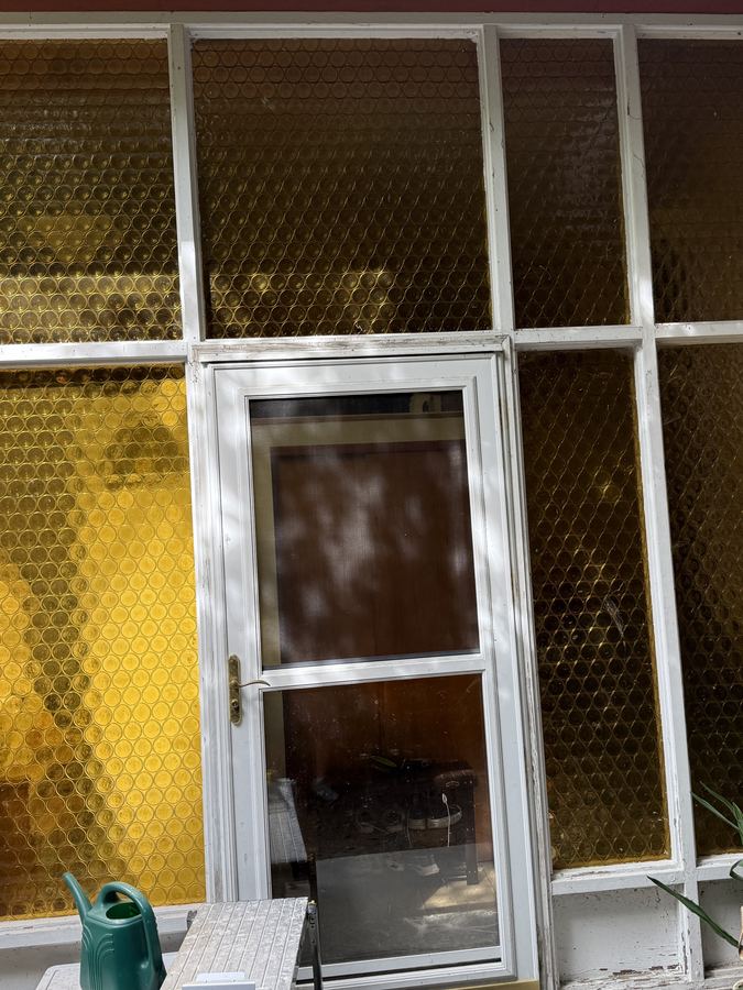 Entry surround with original single-pane amber patterned glass, before replacement
